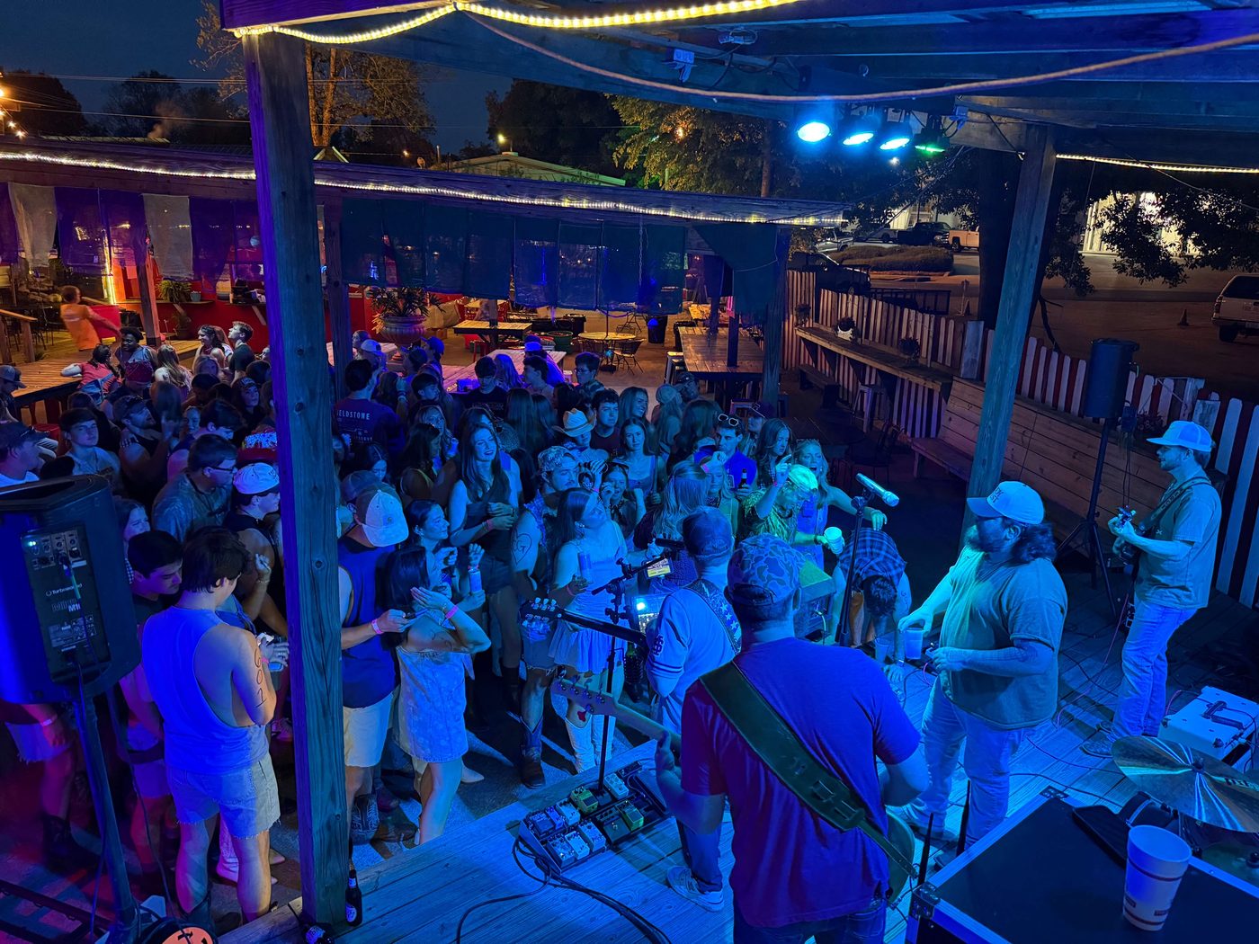 A band playing on The Tipsy Pig's outdoor stage at night
